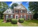 Two-story brick home with manicured lawn and mature trees, a welcoming front exterior at 9900 Colvard Cir, Charlotte, NC 28269