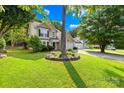 Inviting two-story home with a well-manicured lawn, mature trees, and a spacious driveway at 10908 Delsing Ct, Charlotte, NC 28214