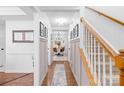 Bright hallway features beautiful trim, staircase with wood banister, and view into the dining area at 10908 Delsing Ct, Charlotte, NC 28214