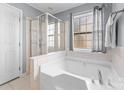 Bright bathroom featuring a large soaking tub with shower and tile surround, perfect for relaxation at 1107 Rachel Anne Dr, Belmont, NC 28012