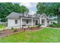 Charming white brick home with a covered porch, manicured landscaping, and a welcoming facade at 1121 S Wendover Rd, Charlotte, NC 28211