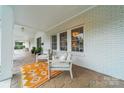 Comfortable outdoor seating area on the covered porch featuring stylish decor and patterned rug at 1121 S Wendover Rd, Charlotte, NC 28211