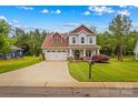 Two-story home with a well-maintained lawn, two-car garage, and a cozy front porch at 1155 Rudder Cir, Salisbury, NC 28146