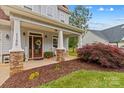 Inviting front porch featuring stone columns, rocking chairs, and a decorative wreath on the front door at 1155 Rudder Cir, Salisbury, NC 28146