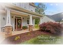 Inviting front porch featuring stone columns, rocking chairs, and a decorative wreath on the front door at 1155 Rudder Cir, Salisbury, NC 28146
