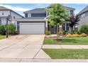 Lovely home with a well-maintained lawn, front porch seating, a basketball hoop, and a two-car garage at 1230 Therns Ferry Dr, Fort Mill, SC 29708