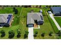 Aerial view of a home featuring a well-maintained lawn and solar panels, with a long driveway at 141 Tall Fern Loop, Mooresville, NC 28117