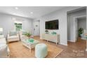 Bright living room with light wood floors, neutral colors, and a view of the front entry at 146 Georgia Sw St, Concord, NC 28025