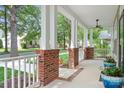 Inviting front porch with brick accents, white columns, and a ceiling fan for comfortable outdoor living at 14923 Almondell Dr, Huntersville, NC 28078