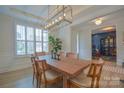 Elegant dining room with modern light fixture and a view into the living room at 15216 Shallow Ridge Rd, Charlotte, NC 28278