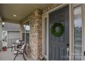 Charming front porch seating area with a wreath on the front door at 15216 Shallow Ridge Rd, Charlotte, NC 28278