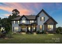 Inviting two-story home with lush lawn, stone details, and a welcoming front porch at 18745 Bluff Point Rd, Cornelius, NC 28031