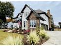 Two-story home featuring stone accents, a well-manicured lawn, and a two-car garage at 18745 Bluff Point Rd, Cornelius, NC 28031