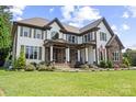 Stunning two-story home with manicured lawn and garden, stone accents, and an elegant front porch at 18745 Bluff Point Rd, Cornelius, NC 28031