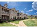 A row of townhomes features inviting exteriors with brick accents, balconies, and green lawns at 20216 Shaffer Bach Ln, Charlotte, NC 28277
