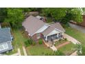 Aerial view of a brick home featuring a covered porch, lush yard, and detached garage at 224 E Steele St, Salisbury, NC 28144