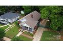Wide aerial view showcasing the brick home with a cozy porch, landscaping, and long driveway at 224 E Steele St, Salisbury, NC 28144