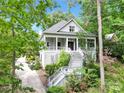 View of the home, revealing an elevated design, and surrounded by mature, verdant foliage at 267 Ikerd Se Dr, Concord, NC 28025