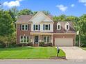 Beautiful two-story brick home with attached two-car garage and well-maintained front lawn at 2821 Providence Spring Ln, Charlotte, NC 28270