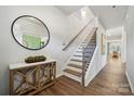 Inviting foyer with hardwood floors, wooden console, and staircase leading to the second floor at 308 Balboa St, Matthews, NC 28104