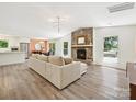 Bright living room boasts a stone fireplace, wood floors, and seamless flow to dining area at 3531 Bon Rea Dr, Charlotte, NC 28226