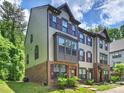 Three-story townhome with brick accents, neutral siding, and dark shutters at 513 Cubitt Ct, Charlotte, NC 28205