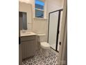 Well-lit bathroom features unique patterned tile flooring and a glass shower door at 5239 Scotts Creek Rd, Indian Land, SC 29707