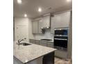 Modern kitchen featuring stainless steel appliances, granite countertops, and stylish gray cabinets at 5239 Scotts Creek Rd, Indian Land, SC 29707