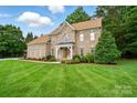 Traditional brick home with lush landscaping, manicured lawn and covered front porch at 6324 Old Fox Hunt Ln, Mint Hill, NC 28227