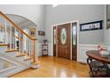 Spacious foyer features hardwood floors, staircase and wooden front door with glass inserts at 6324 Old Fox Hunt Ln, Mint Hill, NC 28227