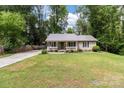 Charming home featuring a cozy front porch, lush lawn, and metal roof at 716 Mooresville Rd, Salisbury, NC 28144