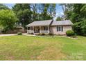 Charming home featuring a cozy front porch, lush lawn, and metal roof at 716 Mooresville Rd, Salisbury, NC 28144