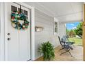 Close up of cozy front porch with seating and decorative wreath on white front door at 73 20Th Sw Ave, Hickory, NC 28602