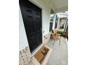 Inviting front porch featuring a stylish black door, a cozy seating area, and a decorative 'hello' welcome mat at 734 Herlong Ave, Rock Hill, SC 29732