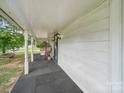 Inviting front porch features a comfortable wicker chair and a welcoming, relaxing ambiance at 828 N Main St, Mount Pleasant, NC 28124
