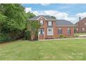 Traditional two-story brick home with a manicured lawn and mature landscaping at 9004 Lauriston Pl, Mint Hill, NC 28227