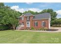 Classic brick home featuring black shutters, a gray accent wall, and lush green lawn at 9004 Lauriston Pl, Mint Hill, NC 28227