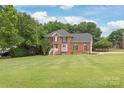 Traditional two-story brick home with a manicured lawn and mature landscaping at 9004 Lauriston Pl, Mint Hill, NC 28227
