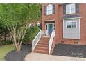 Close-up of the front entrance, featuring a brick stairway, white railing, and a welcoming blue door at 9004 Lauriston Pl, Mint Hill, NC 28227