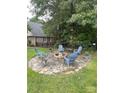 Outdoor fire pit with stone surround and chairs, perfect for relaxing and entertaining in the backyard at 901 Brighton Dr, Kannapolis, NC 28081