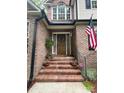 Inviting front porch with brick steps, decorative plants, and an American flag creating a warm welcome at 901 Brighton Dr, Kannapolis, NC 28081