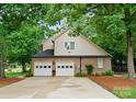 Attached two-car garage featuring white doors and brick exterior with a large driveway at 901 Brighton Dr, Kannapolis, NC 28081