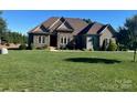 Inviting exterior of a well-maintained home with lush green lawn and mature landscaping at 9125 Dylan Ridge Ct, Concord, NC 28027