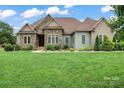 Charming home displaying a well-manicured lawn, complemented by stone and siding exterior finishes at 9125 Dylan Ridge Ct, Concord, NC 28027