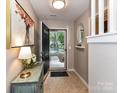 Inviting entryway with tiled floor, artwork, console table with lamp and an open door view of the outside at 9530 Elizabeth Townes Ln, Charlotte, NC 28277