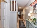 Hallway features neutral walls, stylish console table, rug, and artwork leading to the staircase and other rooms at 9530 Elizabeth Townes Ln, Charlotte, NC 28277