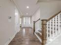 Inviting foyer features hardwood floors, a staircase with wooden banister, and views to the front door at 1048 Harbor Bay Dr, Indian Land, SC 29707