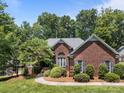 Well-maintained brick home with a curved walkway, manicured shrubs, and mature trees, showcasing charm at 10501 Mount Olive Dr # 7, Mount Pleasant, NC 28124