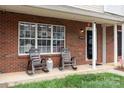 Inviting front porch features brick facade, rocking chairs, and a cozy, welcoming atmosphere at 10548 English Setter Way, Charlotte, NC 28269