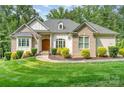 Beautiful home with a manicured lawn, inviting walkway, and lush landscaping at 10874 Rise Ln, Fort Mill, SC 29707
